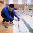 Wake Forest sophomore Yinger "Eagle" Jin ('16) demonstrates his wave-powered electric generator in the pool in Reynolds Gym. The system harnesses the wave action as it compresses air inside the tube, which turns a small turbine that generates electricity.