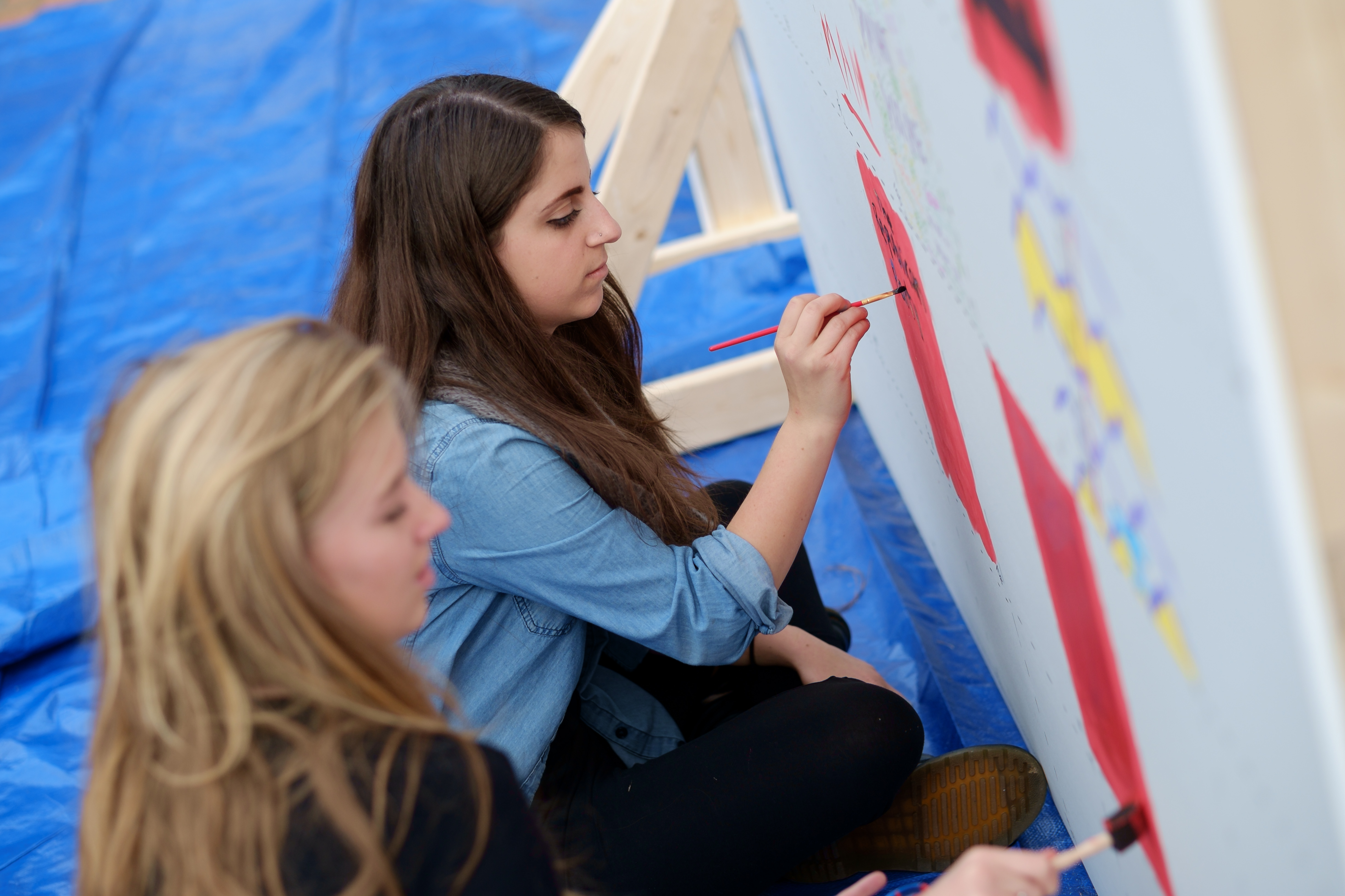 Andrea Becker ('16), in blue, and Marlee Stark ('17), in black, work on their panels.