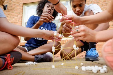 Lauren Brown, left, from Brooklyn, NY, and Dana Harvey, from Atlanta, work with their teammates to build structures out of marshmallows and spaghetti.