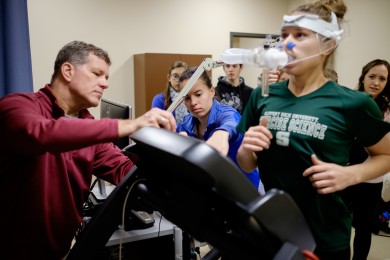HES professor Pete Brubaker teaches first-year graduate students in the cardiovascular lab. Natalie DiCicco, in green, undergoes a cardio test.