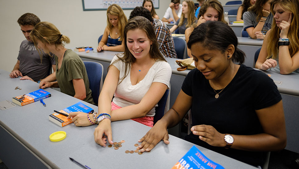 A group of first-year students do activities related to the book “Predictably Irrational” in a discussion led by chemistry professor Al Rives.