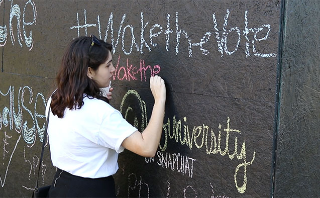 A student writes on a structure for Wake the Vote