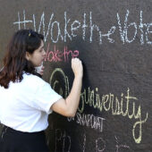 A student writes on a structure for Wake the Vote