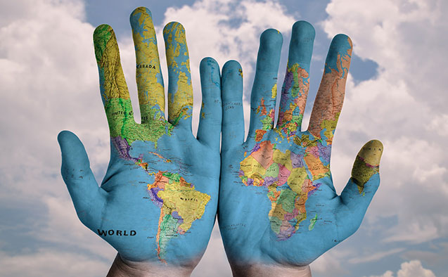 An image of hands with a map of the world painted on them