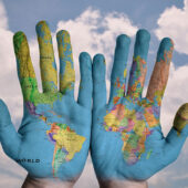 An image of hands with a map of the world painted on them