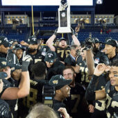 Wake Forest players hold the Military Bowl trophy.