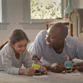 An image from a Barbie commercial of a dad and daughter playing with Barbies