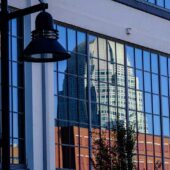 The Winston-Salem skyline reflected in a window of the Wake Downtown building