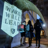 Wake Forest students walk by a Wake Will Lead branded banner on campus.