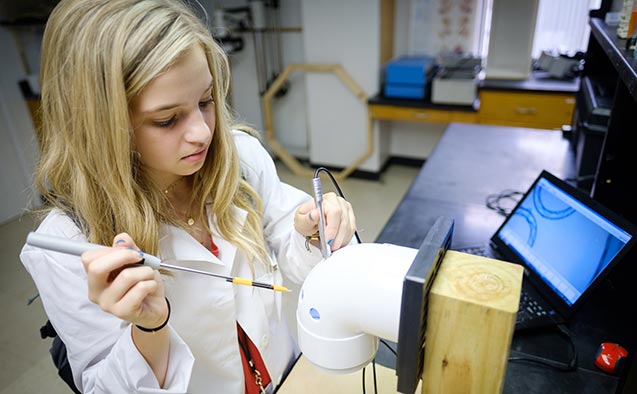 A student in Wake Forest's summer immersion program operates on a plastic 