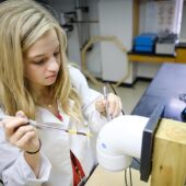 A student in Wake Forest's summer immersion program operates on a plastic "pig joint."