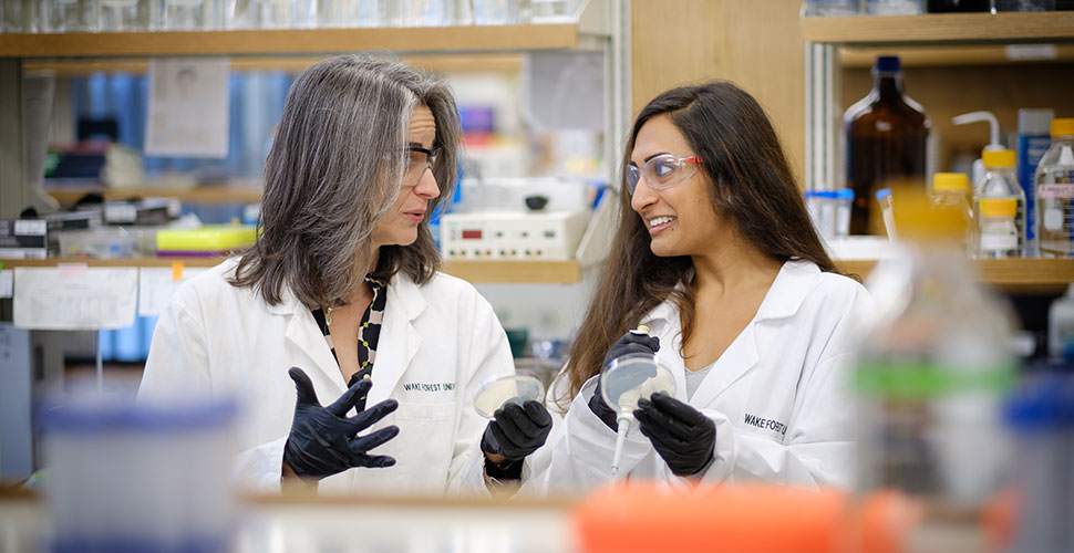 Rebecca Alexander, director of academic programming for Wake Downtown, works with Nisha Patel ('17) in her lab.