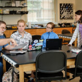 Wake Forest biology professors Dan Johnson and Sabrina Setaro talk with graduate students Noah Bressman and Jenny Howard about new methods for grading science writing, in a lab in Winston Hall.