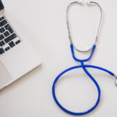 Stock image of a stethoscope and laptop.