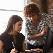 Two Businesswomen Working On Computer In Offic