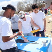 Students at WFU paint desks for students from a local elementary school