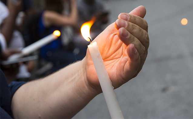 Hand holding a candle during a vigil