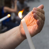 Hand holding a candle during a vigil