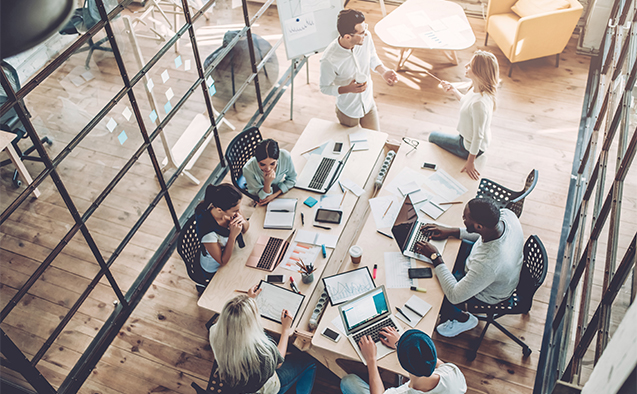 Workers in an office around a conference table