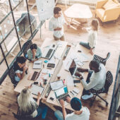 Workers in an office around a conference table