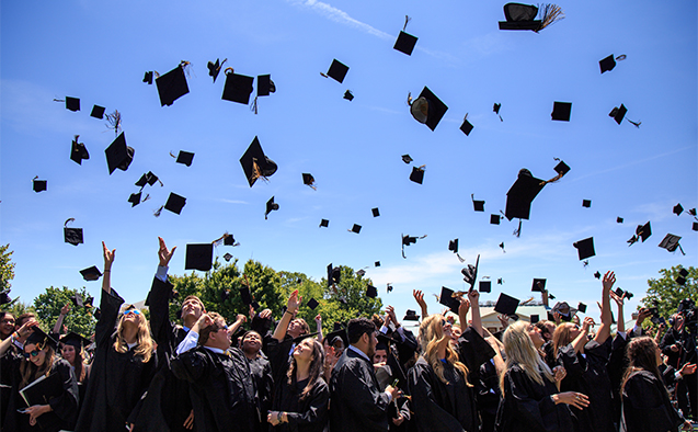 Students toss their caps in the air at commencement