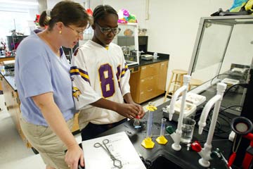 Angela King (left) of the Wake Forest chemistry department assists arising high school student with a science experiment during the annual SciMax Summer Enrichment Institute at Wake Forest.