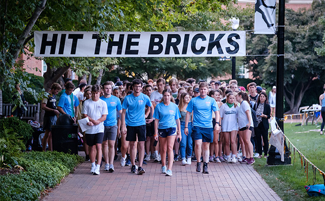 Hit the bricks sign above walkers and runners.