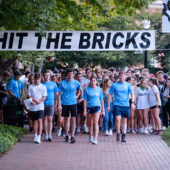 Hit the bricks sign above walkers and runners.