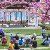 Audience listens to speaker on outdoor stage