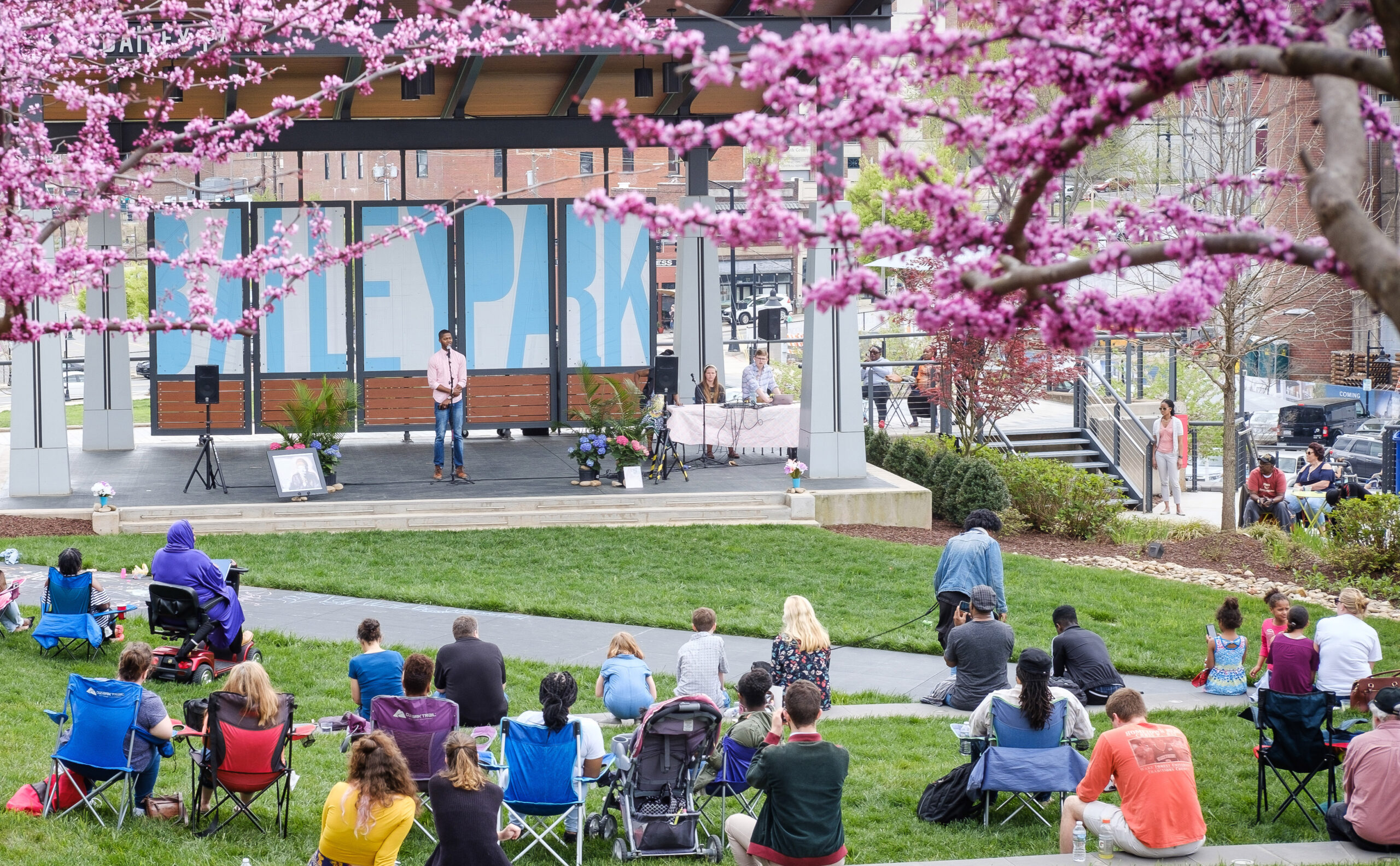 Audience listens to speaker on outdoor stage