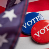 US flag with red and blue "Vote" pins