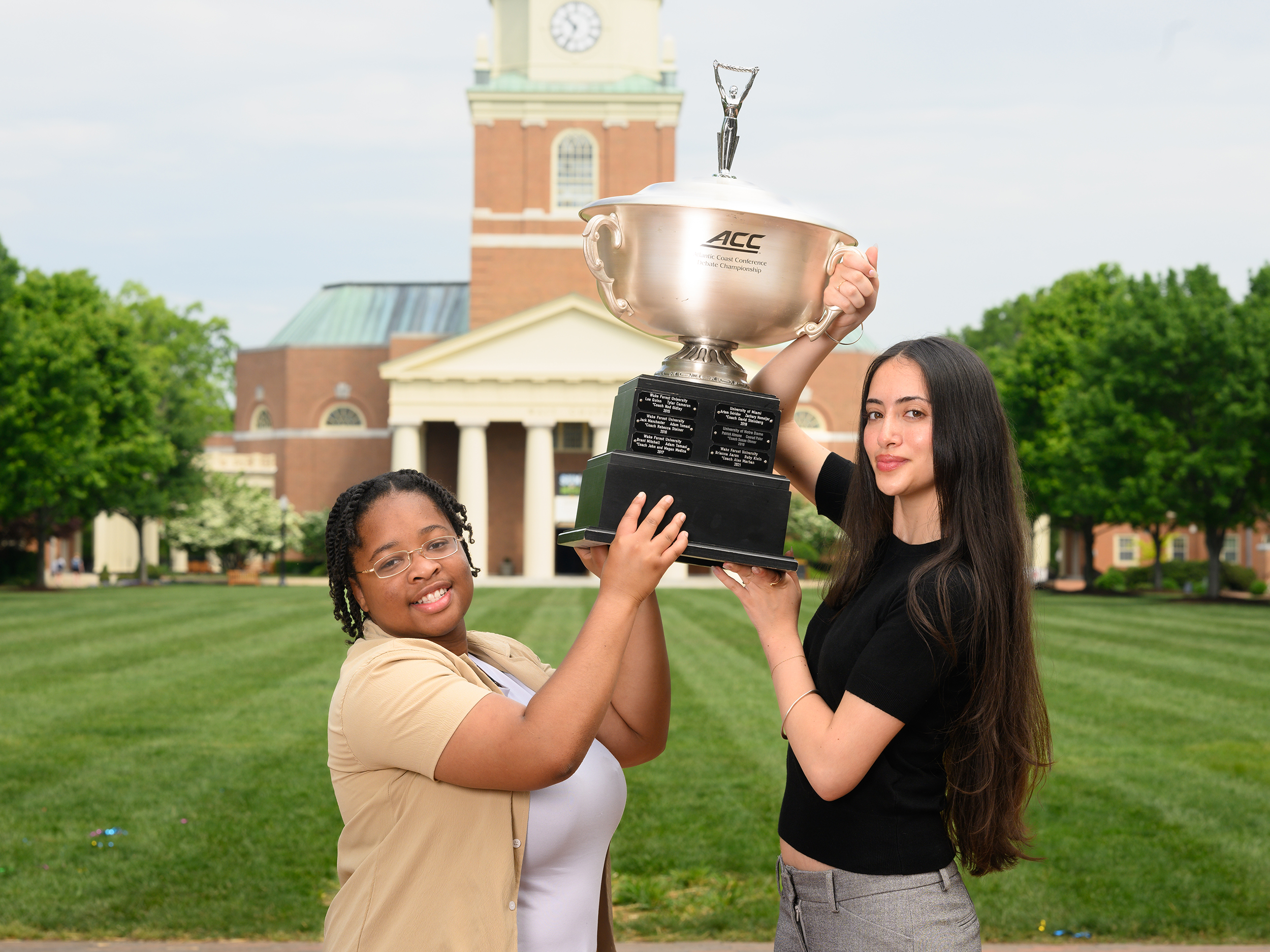 Wake Forest University sophomores Destiny Hale and Hanna Shakarov pose for photos together and with their 2025 ACC Debate Champsionship trophy on Hearn Plaza with Wait Chapel in the background on Wednesday, April 30, 2025.
