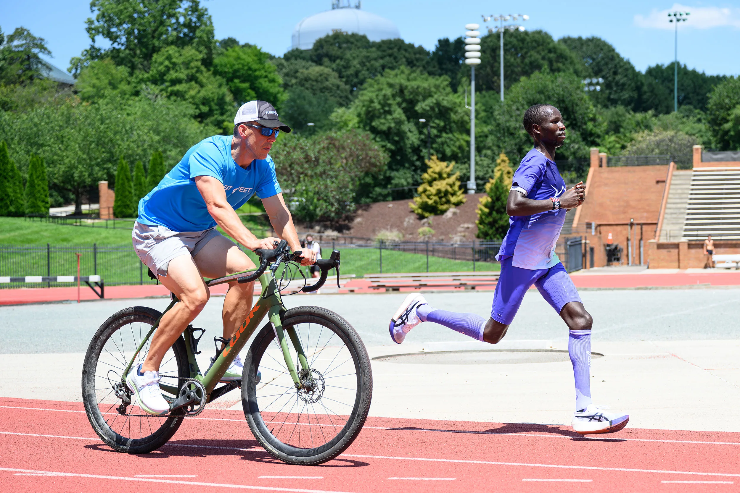 Wake Forest alum and local Fleet Feet owner Keith Davis paces marathoner John Korir on a bike to track his heart rate.