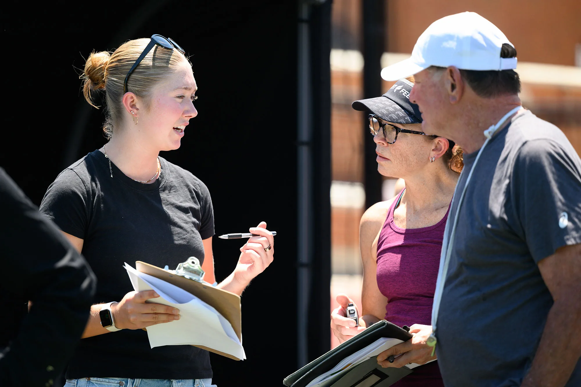 Undergraduate researcher Josie Rill (left) goes over the lactate threshold testing protocol with John Korir’s coach, Ron Mann. Wake Forest alum Emily Davis assisted with the testing.