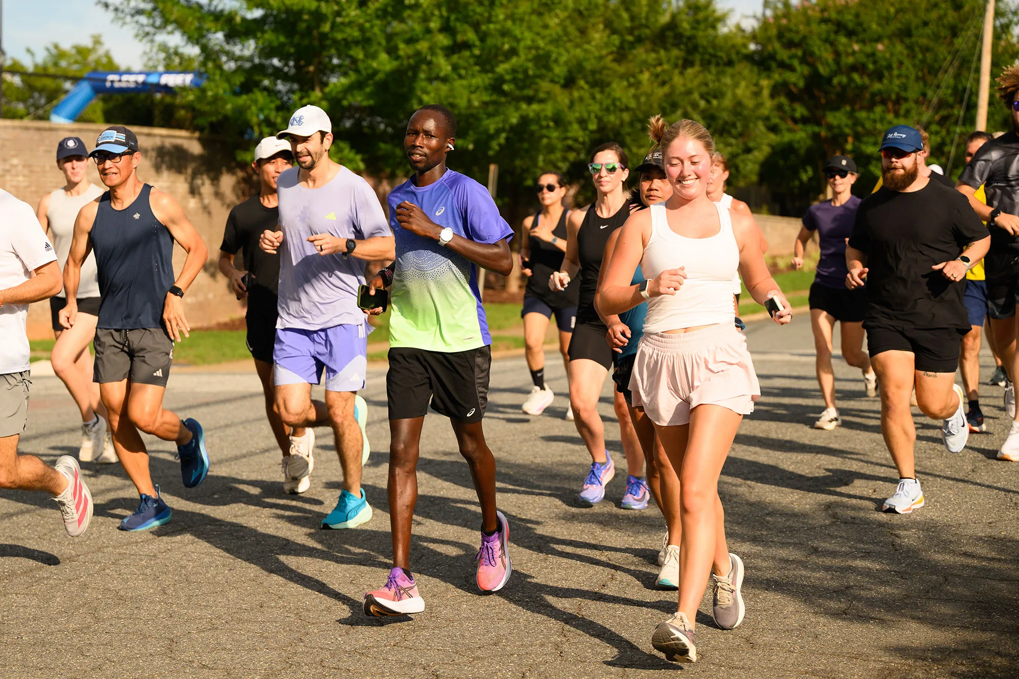 Wake Forest undergraduate researcher Josie Rill (in pink shorts) takes a 5K run with marathoner John Korir during an Aug. 3 fundraiser at Fleet Feet Winston-Salem.