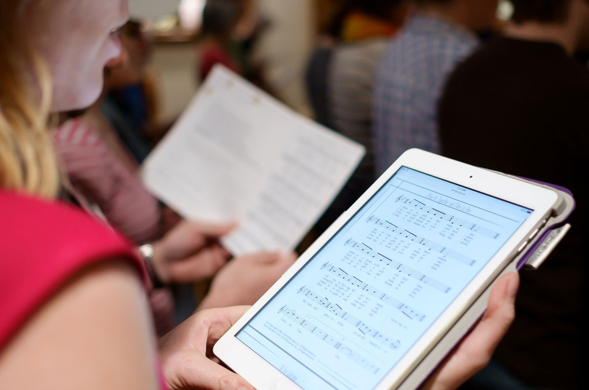 School of Divinity faculty member Katherine Shaner uses her tablet to access a bulletin for a community worship service