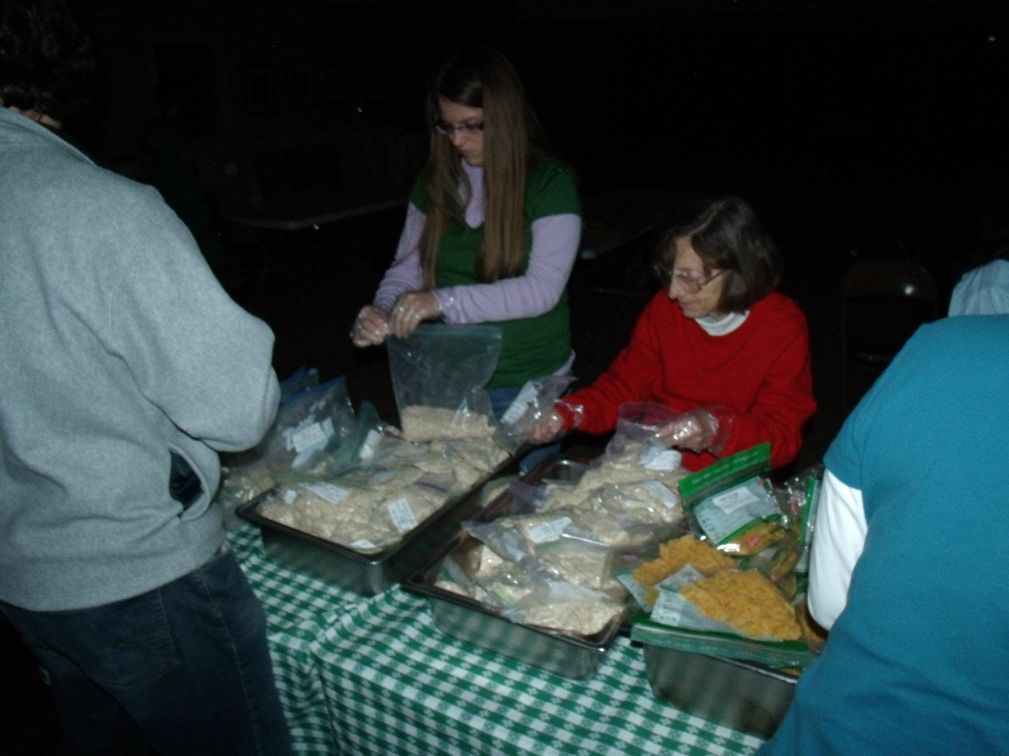 Rev. Cheek (right) and Russell (left) serve a meal to residents in a community during the 2012 travel course