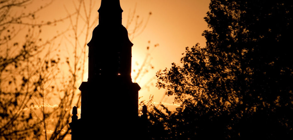 The sun sets behind the bell tower of Wait Chapel, on the campus of Wake Forest University