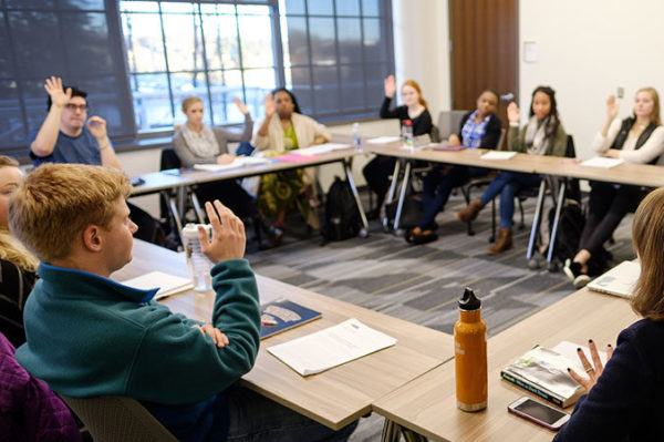 Students raising hands in class