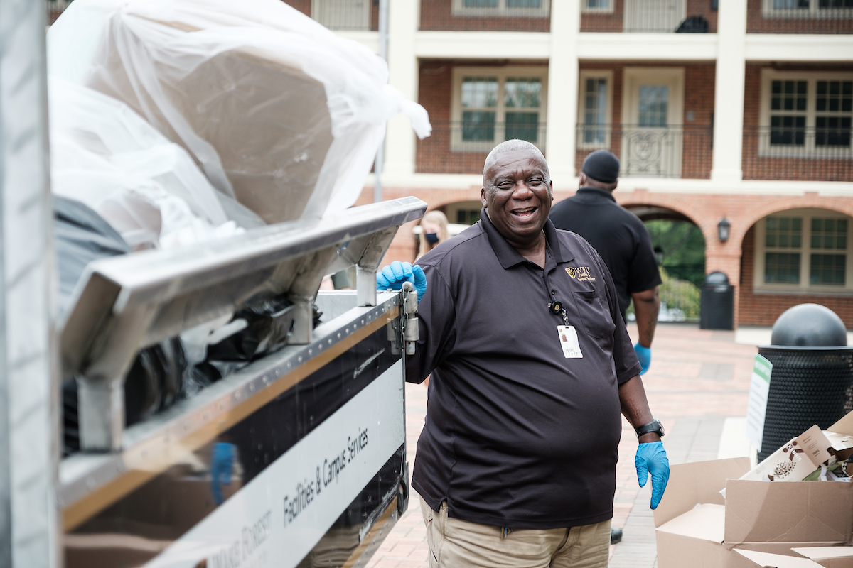 Wake Forest facilities team member Ernie Johnson collects trash outside Taylor Residence on Thursday, August 20, 2020.