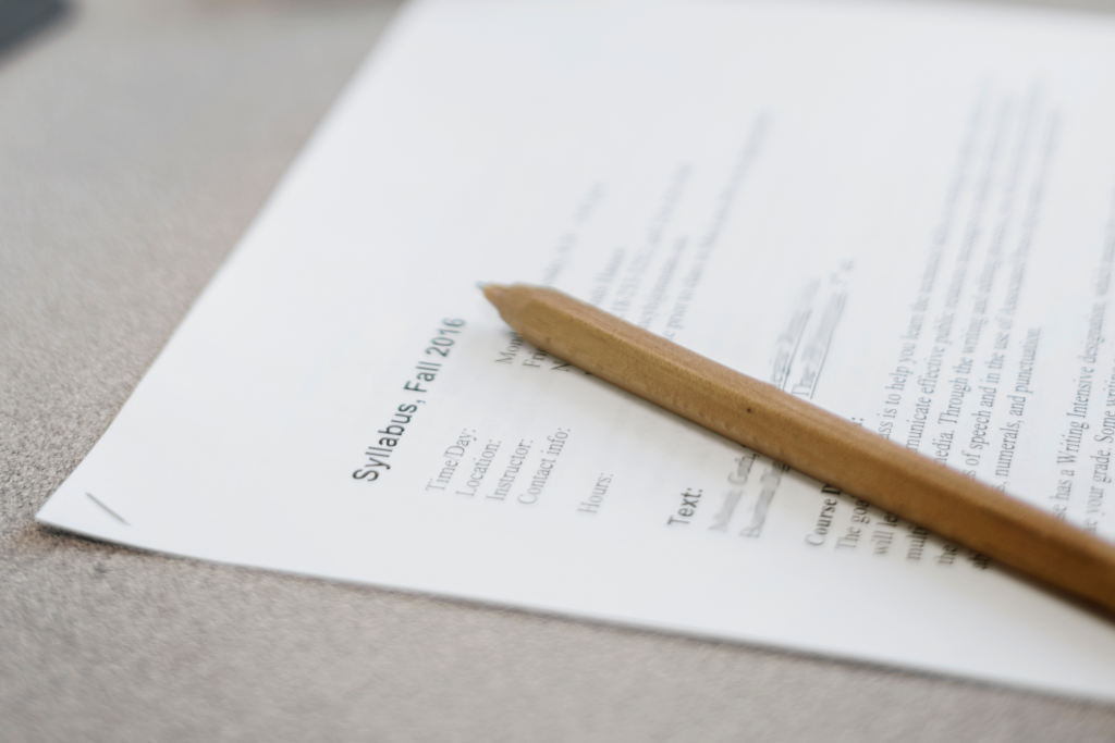 Picture of a pencil sitting on top of a stapled set of paper with "Syllabus, Fall 2016" written on top and the Time of Day, Location, Instructor, and Contact Info visible.