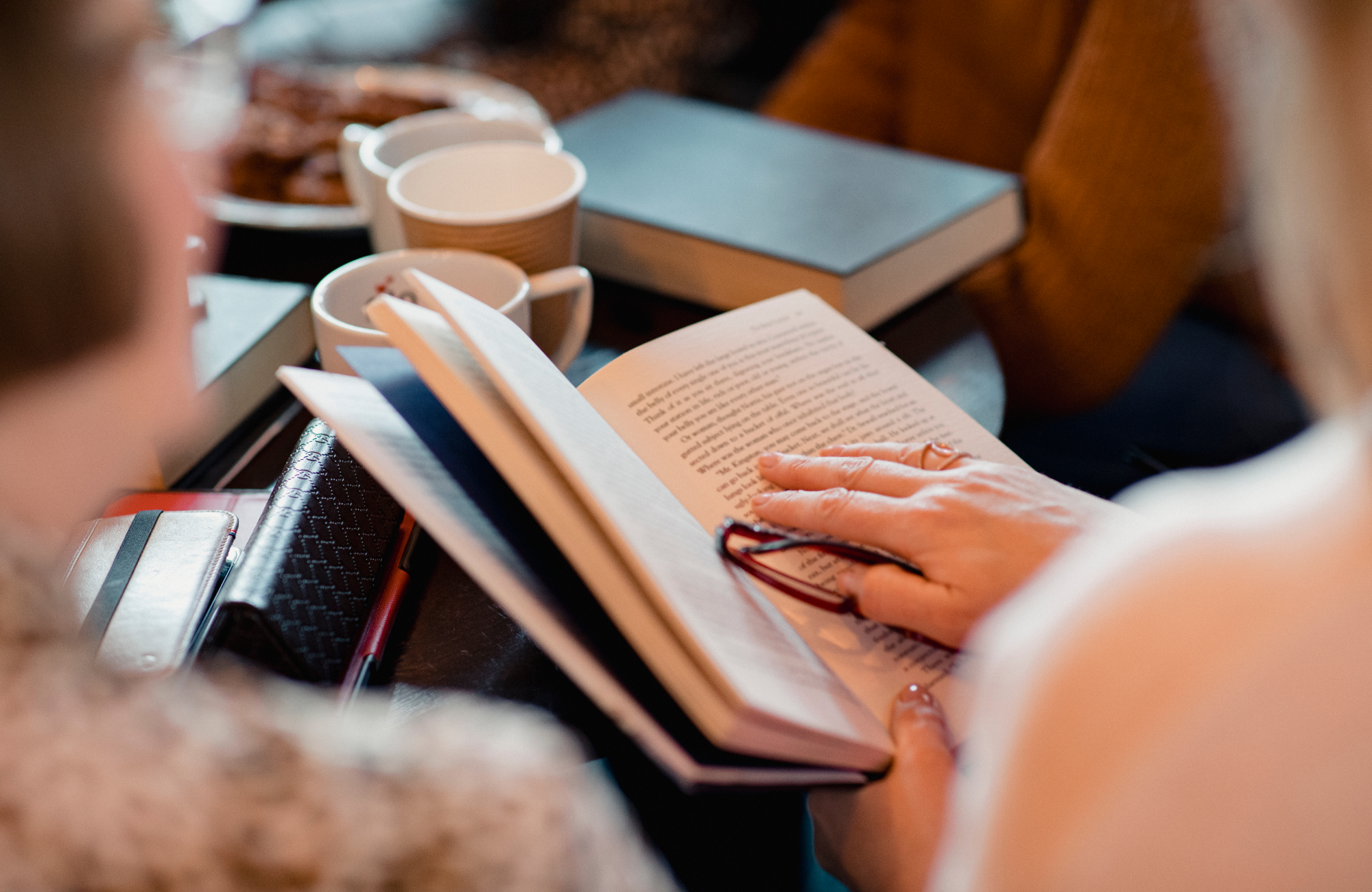 decorative close up of hands of a group of women reading books