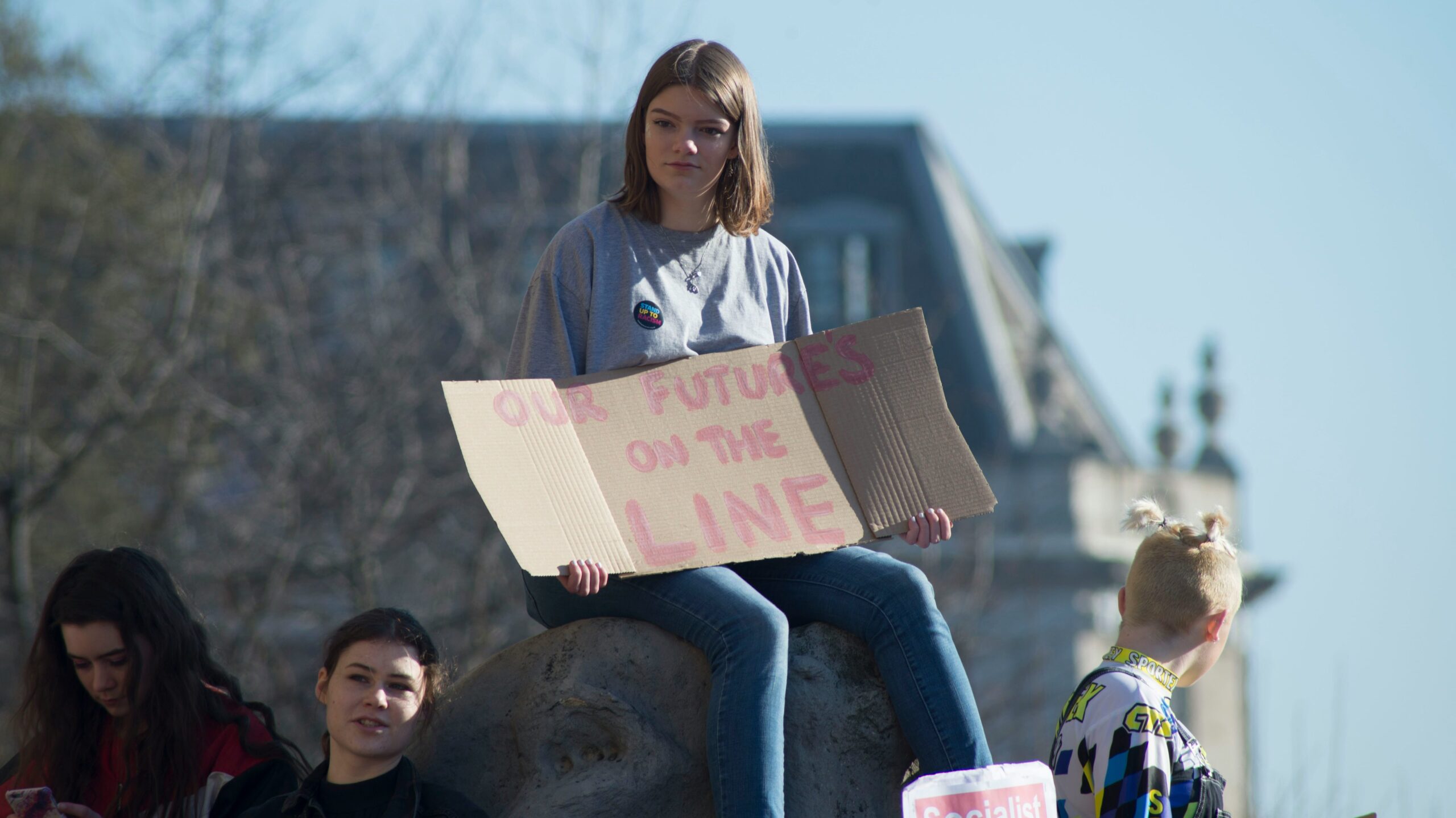 woman holding cardboard signage "our future's on the line"