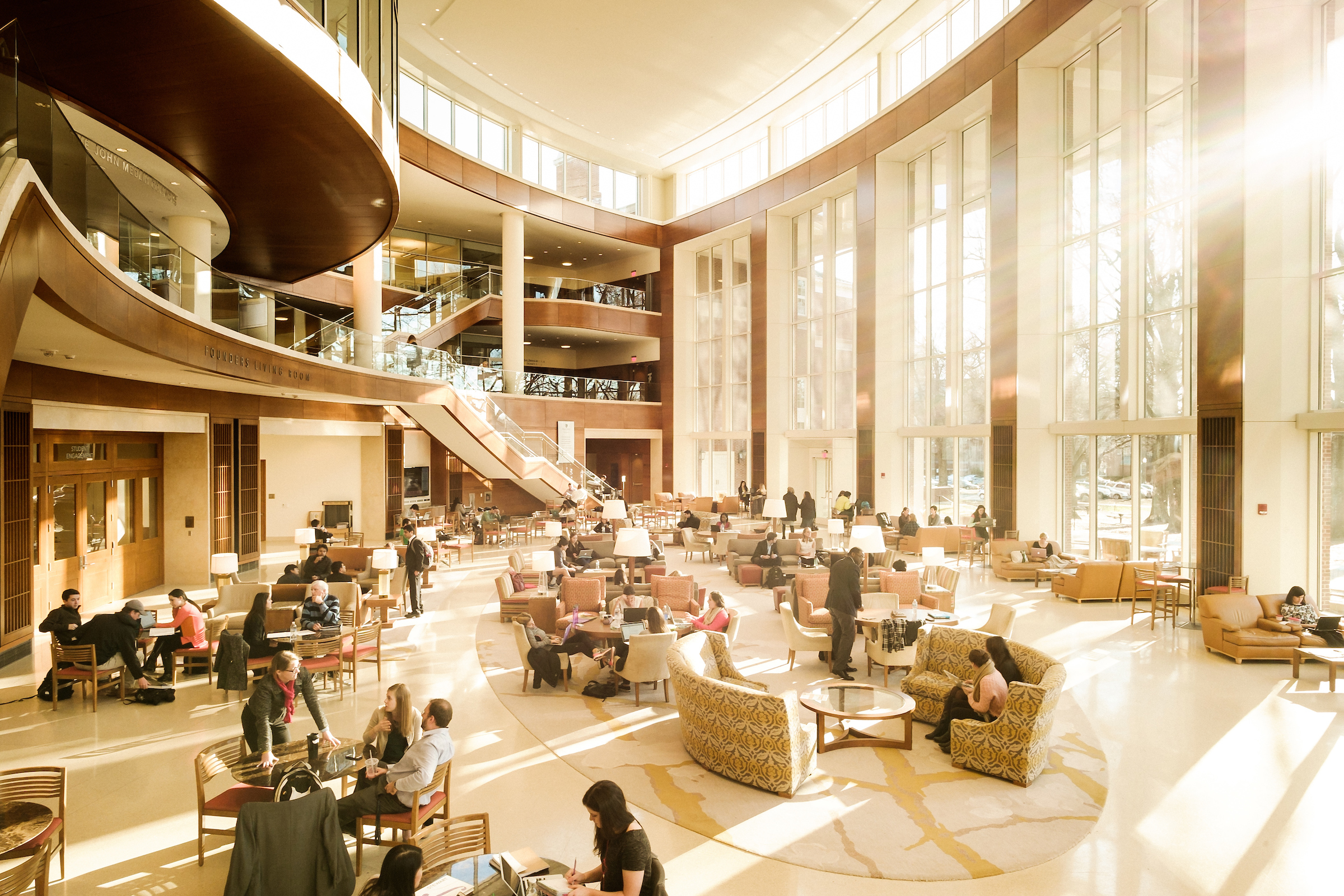 Wake Forest business students work in the atrium of Farrell Hall