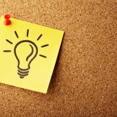 Lightbulb on post it note on bulletin board