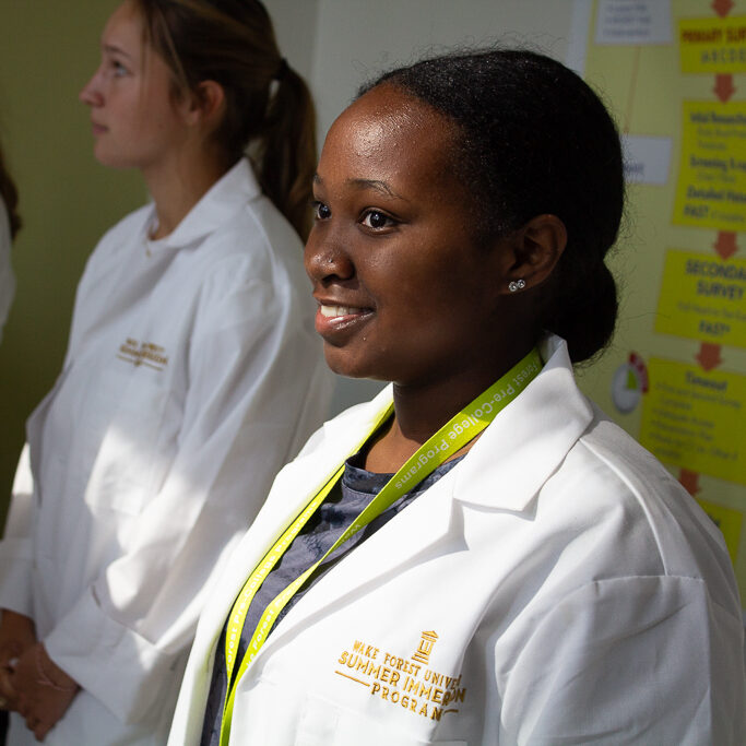 Medicine Institute student smiling in her white coat.