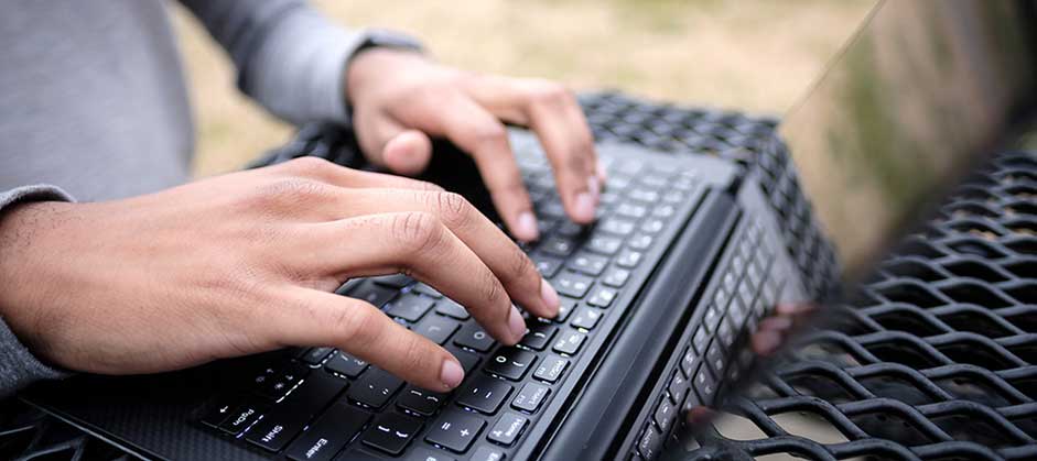 Student typing on laptop