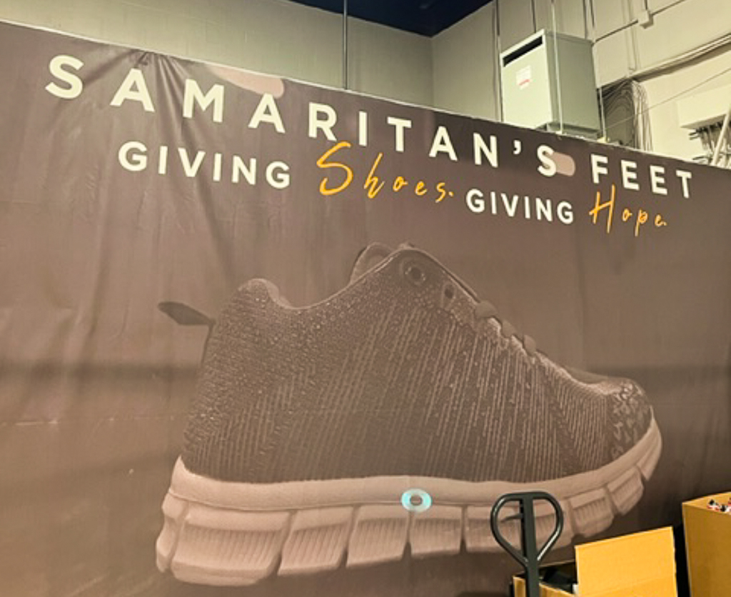 Samaritan's Feet sign that reads, "Giving shoes, giving hope".