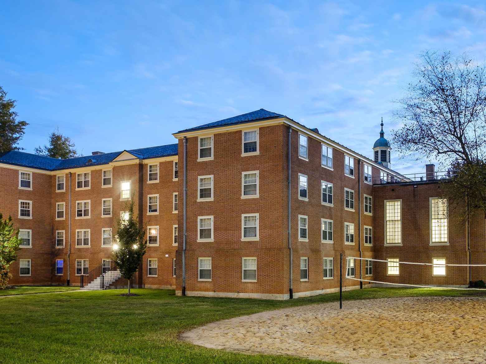 Volleyball court and rear view of Johnson residence hall