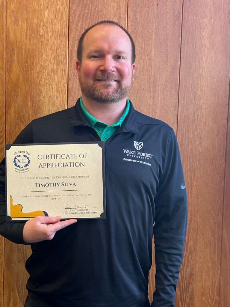 Tim Silva holding a Certificate of Appreciation from the Pi Alpha chapter of Chi Sigma Iota.